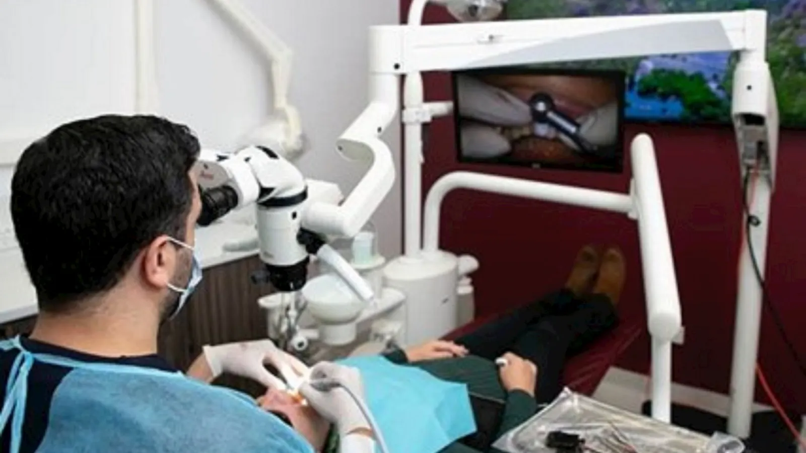 Dentist at the surgical microscope during a treatment